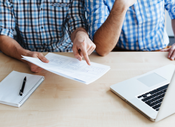 two men collaborating next to laptop